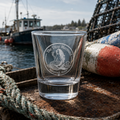 The Titsy Mermaid etched shot glass on a coastal harbor dock with lobster buoy and fishing boat — frosted Harpswell Maine engraving